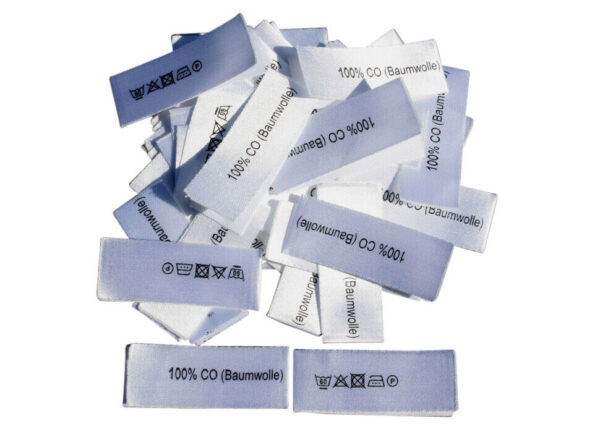 mittig gefaltene Textiletiketten mit dem Aufdruck 100% Baumwolle und Pflegesymbole 10mm schmahl.