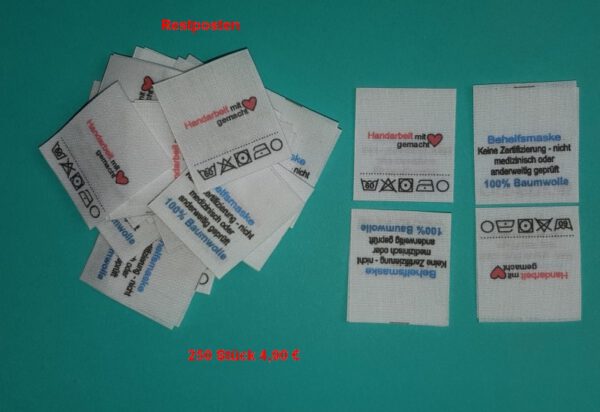 Handarbeit, 100% Baumwolle, Behelfsmaske, Pflege 60° X 1 1 O, Mittelfalte mittig gefaltene Labels mit Aufdruck wie abgebildet. Baumwoll-Mischband, weiß : 25 x 27mm; Fertigmaß nach Mittelfalte: 25 x 27mm.