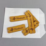 gelaserte Labels, mit Prägung: Handarbeit. Abmessungen: 16 x 55mm in etwa. mit Annähmöglichkeit rechts + links | + Motiv Schmetterling